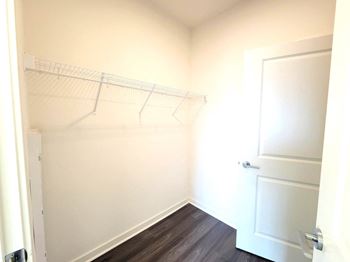 A white closet with a white door and a white wall